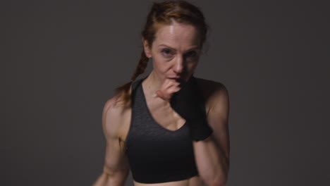 Studio-Portrait-Of-Mature-Woman-Wearing-Gym-Fitness-Clothing-Exercising-Sparring-At-Camera-4